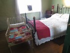 IMG_3106  The parents' bedroom with a crib for the latest baby.JPG